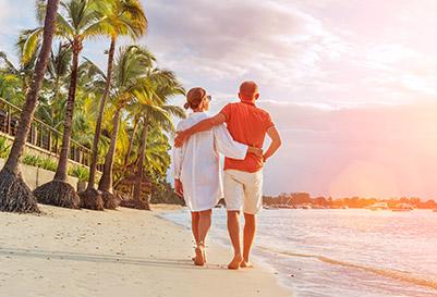 A man and woman taking a romantic stroll on the beach