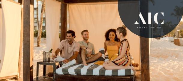 AIC Hotel Group beachfront cabana with friends relaxing on daybed in tropical resort setting
