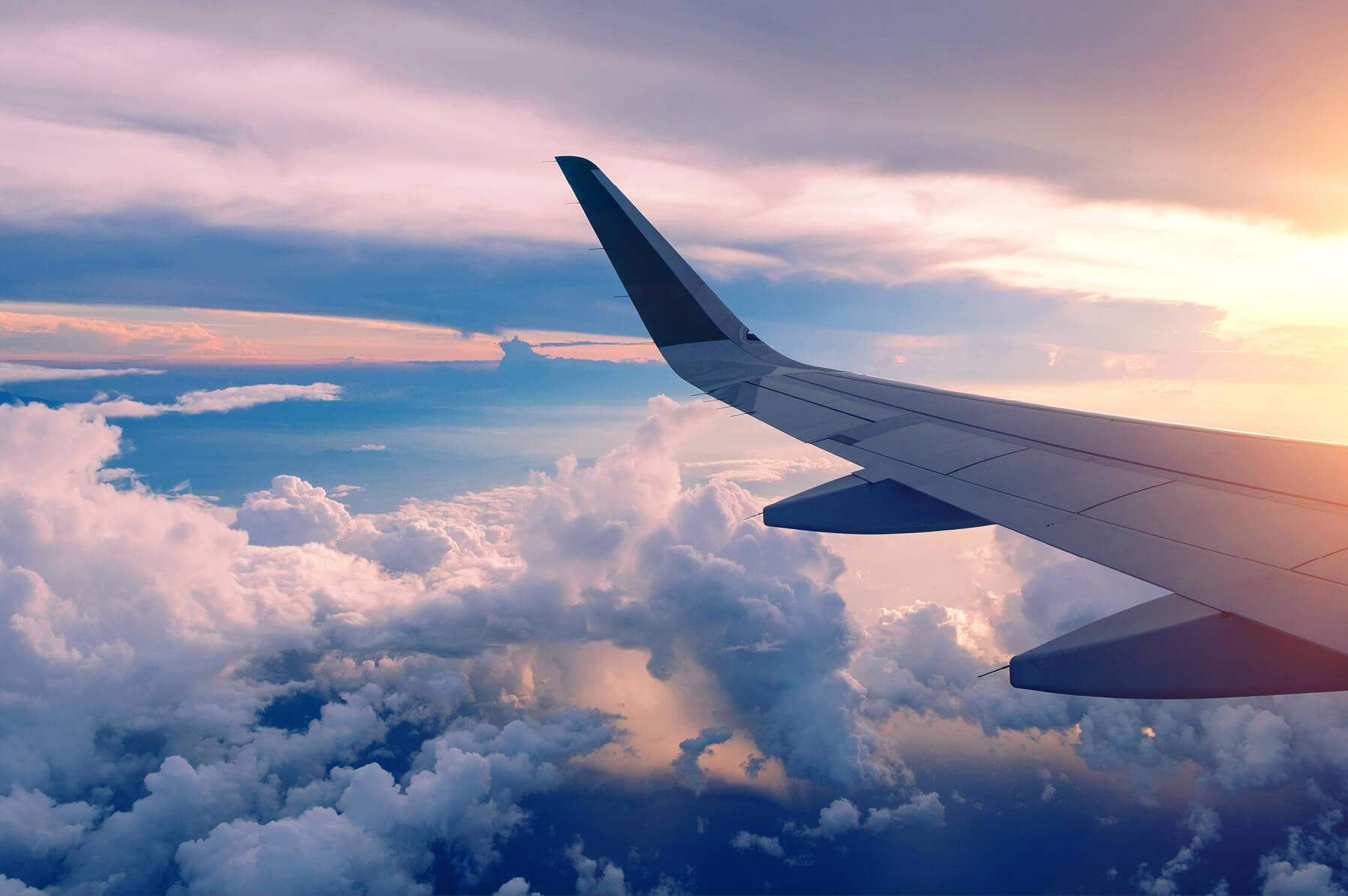 A view of a plane wing soaring through the sky